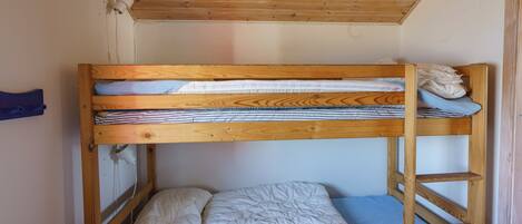 Una cama individual con estructura de madera, colchón azul y colcha blanca.