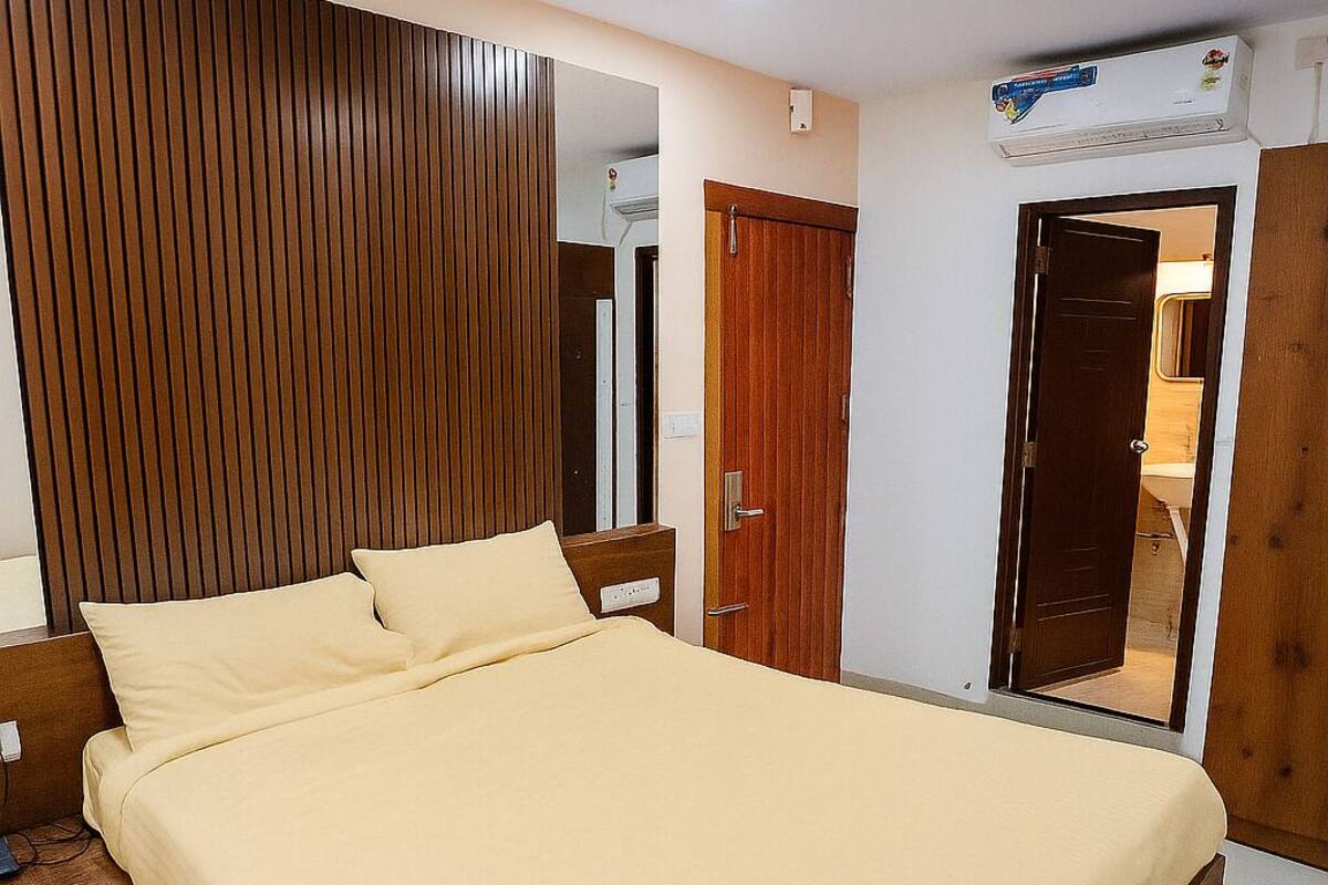 Un dormitorio moderno con una cama grande, cabecera de madera y ventilador de techo.