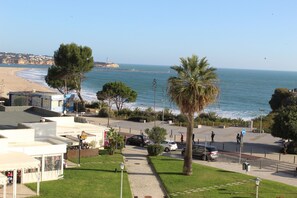 A coastal view with a beach, palm trees, and a promenade. - Praia Rocha Balcony First Line Beach View Studio (Portimão)