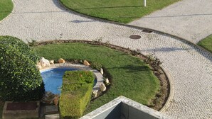 A circular pool with a paved walkway surrounding it, a flagpole, and a well-maintained lawn. - Praia Rocha Balcony First Line Beach View Studio (Portimão)