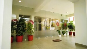 Eine moderne Lobby mit Glaswänden, Topfpflanzen und Fliesenboden.