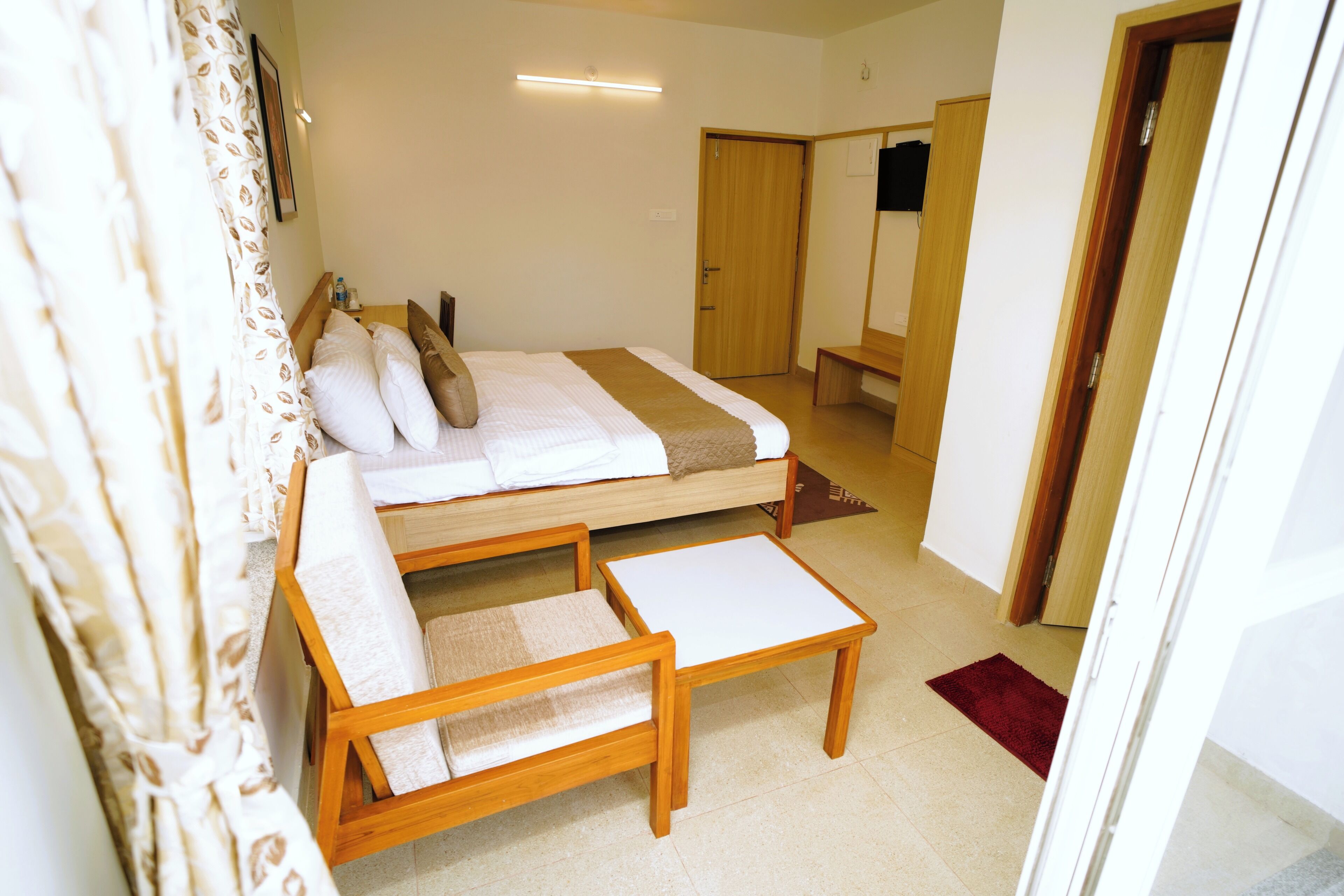 Ein Schlafzimmer mit einem Bett, einem Holzstuhl, einem kleinen Tisch und einem Kleiderschrank.