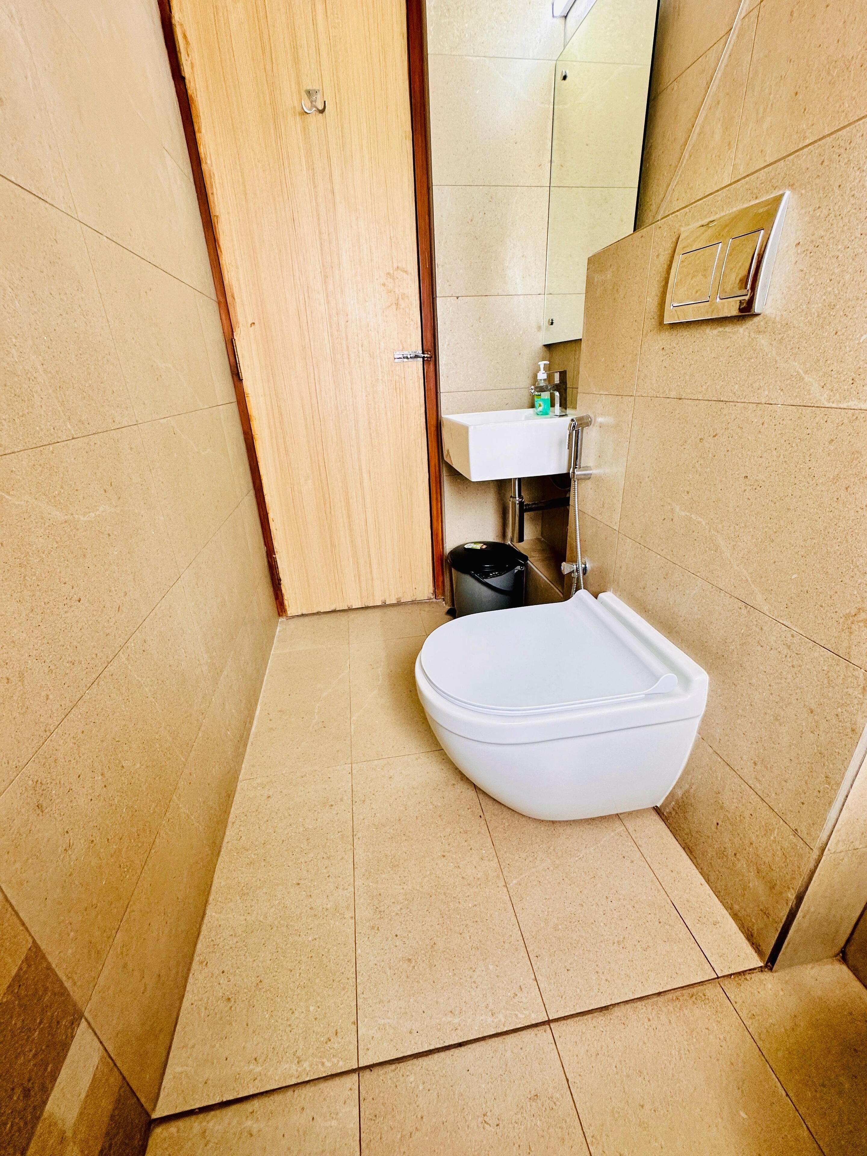 A bathroom with a white toilet, a sink, and a mirror.