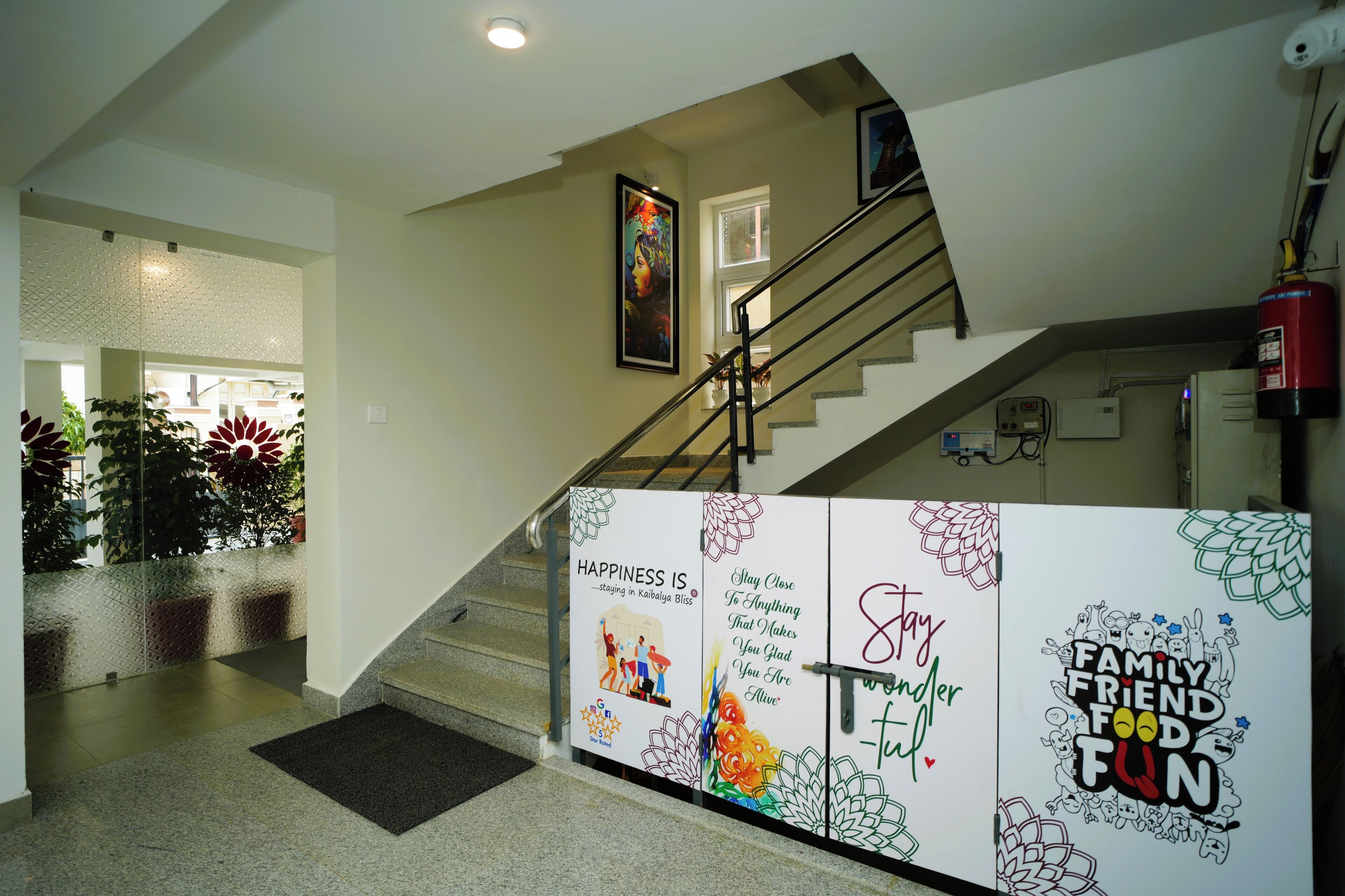 Un escalier avec une rampe, un extincteur et un mur orné d’affiches motivantes.