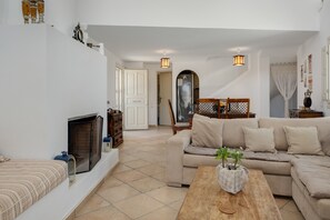 Una sala de estar con chimenea, sofá y mesa de centro.