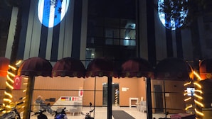 A hotel entrance with a covered waiting area, a reception desk, and parked motorcycles. - Nativo Hotel (Antalya)