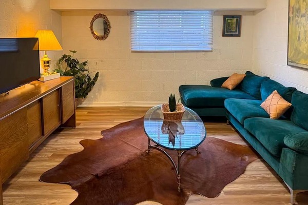 Relax in a cozy living room featuring a sleek TV and a stylish glass center table. It’s the perfect spot to unwind and feel right at home.