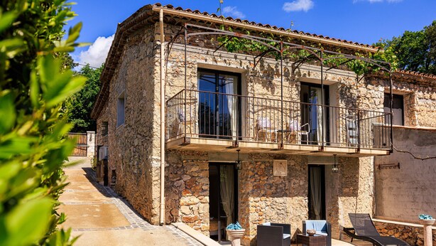 A stone building with a balcony, outdoor seating, and a clear sky. - Le petit Mas - Calme 5mn from Vence (Vence)