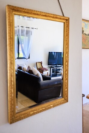 A living room with a black sofa, a television, and a chair.