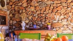 A rustic dining area with a stone wall, wooden table, and chairs. - Le petit Mas - Calme 5mn from Vence (Vence)