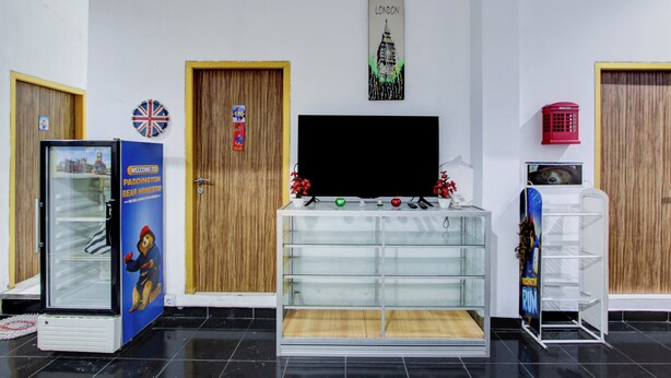 A reception area with a glass display case, a television, and wooden doors. - Hotel O Yogyakarta near Gembiraloka Zoo formerly Paddington Bear Homestay (Banguntapan)