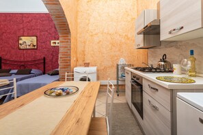 A compact kitchen with a stove, sink, and a small dining area with a table and chairs.