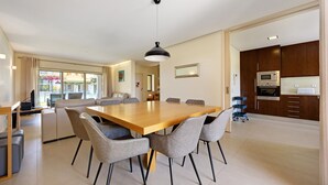 Een moderne keuken met donkere houten kastjes, een ingebouwde magnetron en een roestvrijstalen koelkast.