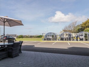Un parking doté d’espaces de stationnement avec des zones d’assise abritées et d’une table avec un parasol.