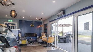 Ein modernes Interieur mit Kamin, Sitzecke und großen Fenstern mit Blick auf den Parkplatz.