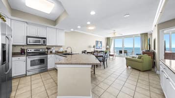Condo com design assinado, 3 quartos, cozinha, vista para a praia | Cozinha privada | Geladeira, micro-ondas, fogão, cooktop