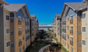 A residential building with multiple floors, balconies, and a central courtyard with landscaping.