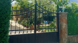 Una entrada protegida por una reja con un letrero que dice "ADAHAN APART" y un número de contacto.