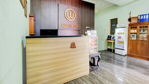 A reception desk with a logo, a refrigerator, a wooden cabinet, and a small table with a sign. - Hotel O Yogyakarta near Taman Sari formerly Widitya Inn (Yogyakarta)