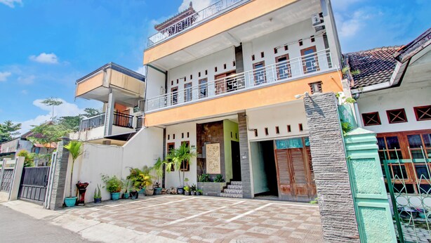 A two-story house with a balcony, a gated entrance, and potted plants. - Hotel O Yogyakarta near Taman Sari formerly Widitya Inn (Yogyakarta)