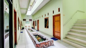 A hallway with a central water feature, wooden doors, and a staircase. - Hotel O Yogyakarta near Taman Sari formerly Widitya Inn (Yogyakarta)