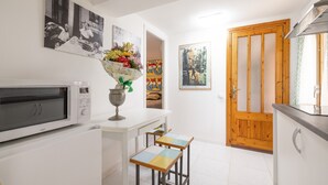 Una cocina con microondas, un florero con flores y una puerta de madera.