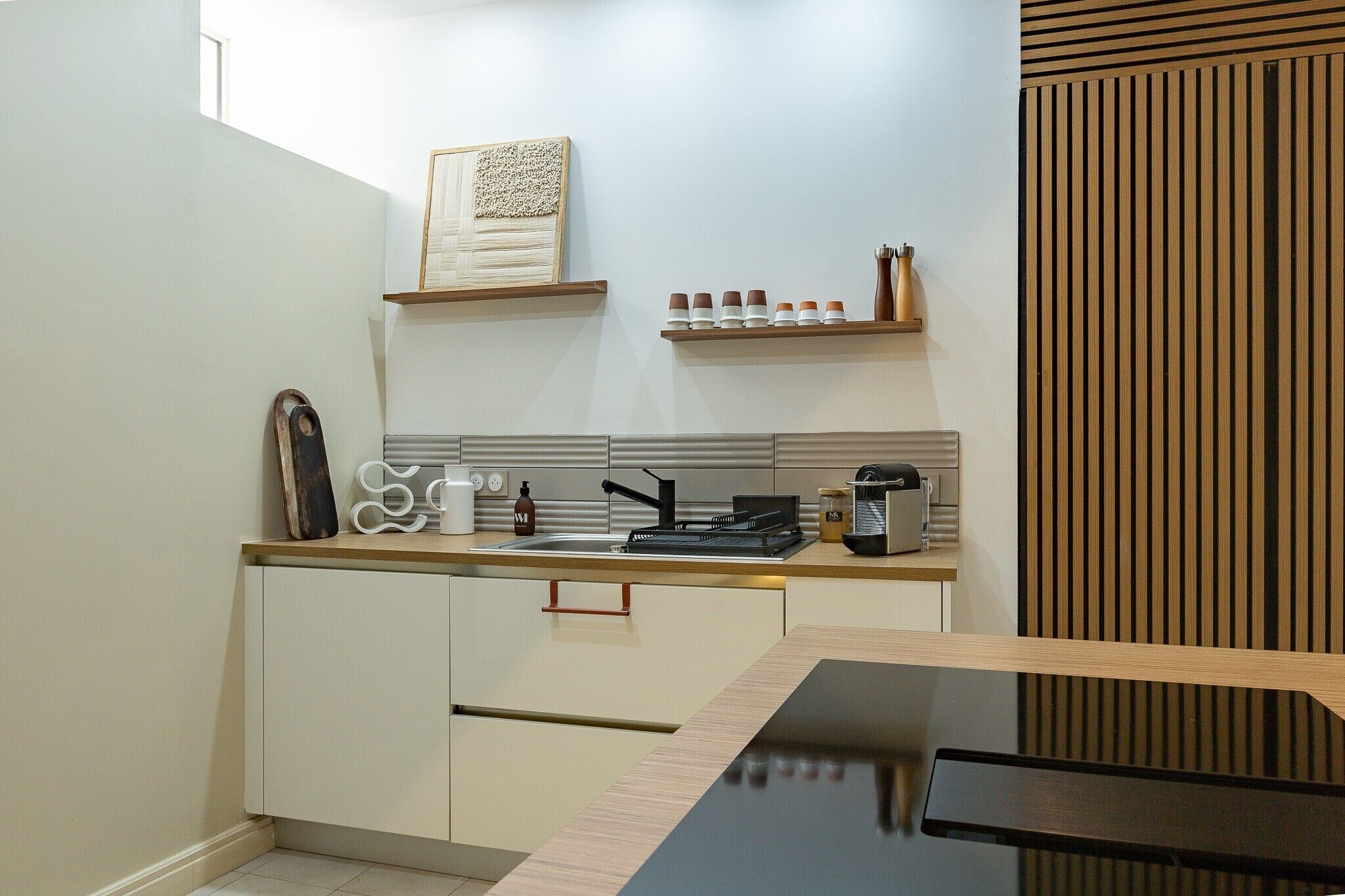 Een moderne keuken met een aanrecht, gootsteen en een wand van hout.