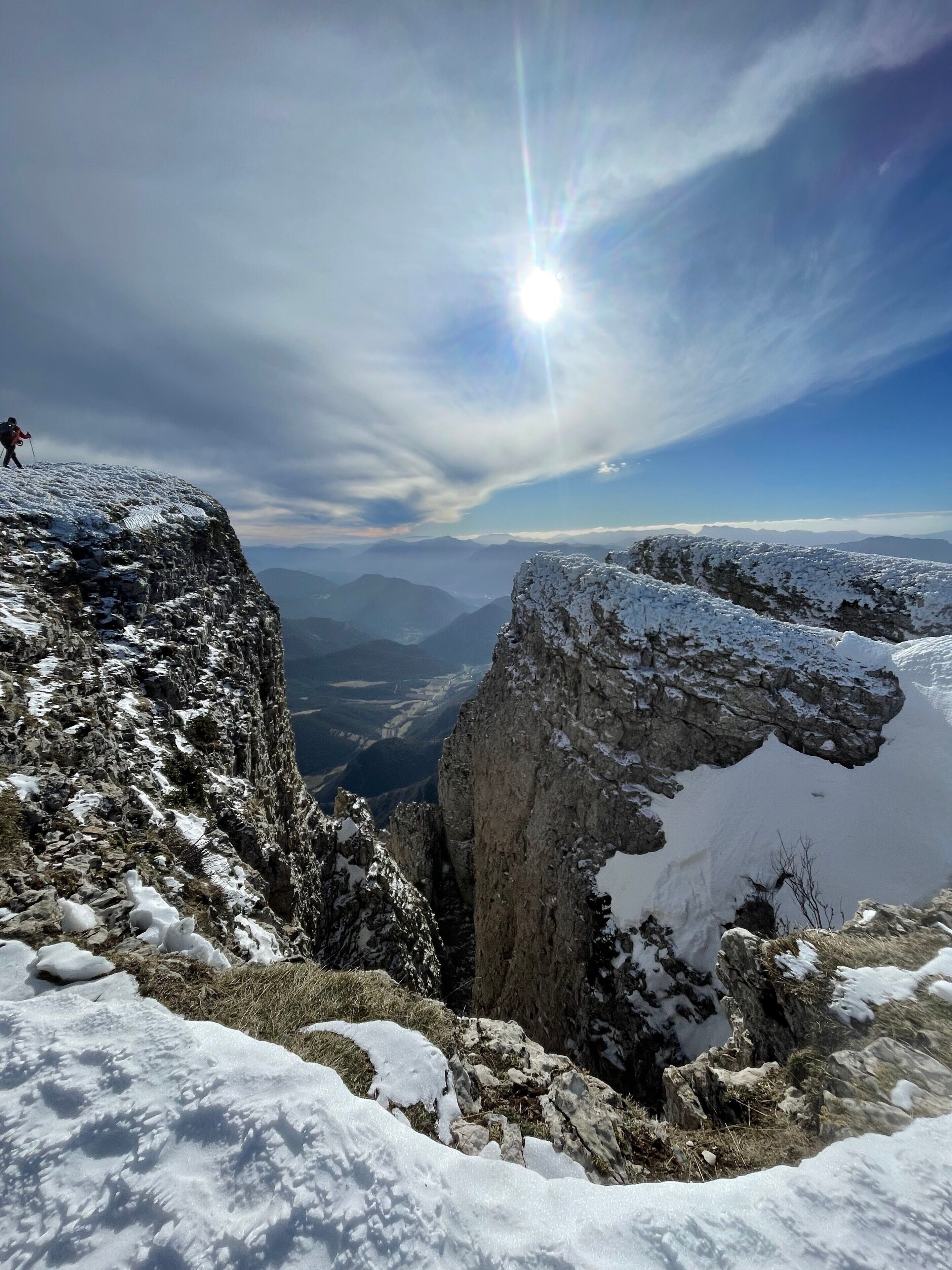 Un paysage montagneux aux sommets enneigés, sous un ciel dégagé.