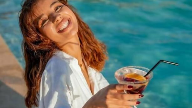 A person sitting by a pool with a drink in hand. - Agafay Tenere Luxury Camp (Agafay)