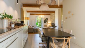 Eine moderne Küche mit Essbereich, Holzbalken und einem großen Tisch.
