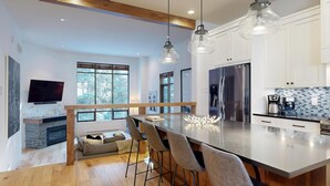 Una cocina moderna con una isla grande, electrodomésticos de acero inoxidable y una zona de bar.