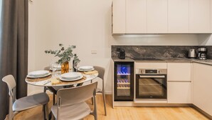 A compact kitchen with a built-in oven, a coffee maker, and a small refrigerator. - Rezia Apartments by Rent all Como (Como)