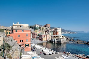 A coastal town with colorful buildings, a marina with boats, and a clear blue sky.