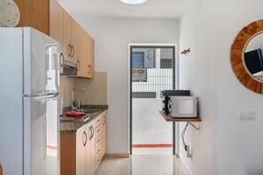 A modern kitchen with a refrigerator, microwave, and sink.