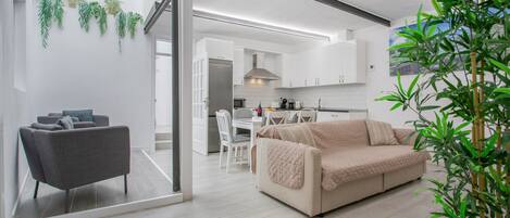 Un espacio habitable moderno con sofá, comedor y cocina.