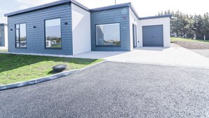 Un bâtiment moderne à deux étages, doté de grandes fenêtres et d’un garage.