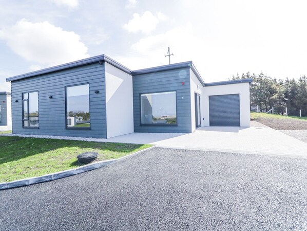 A modern two-story building with large windows and a garage. - Number 6 Villa - The View (Bunbeg)