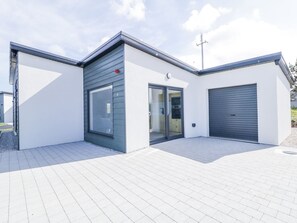 A modern building with a garage, a large window, and a door. - Number 6 Villa - The View (Bunbeg)