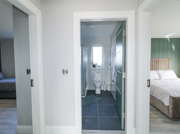 A modern bathroom with a toilet, sink, and shower.