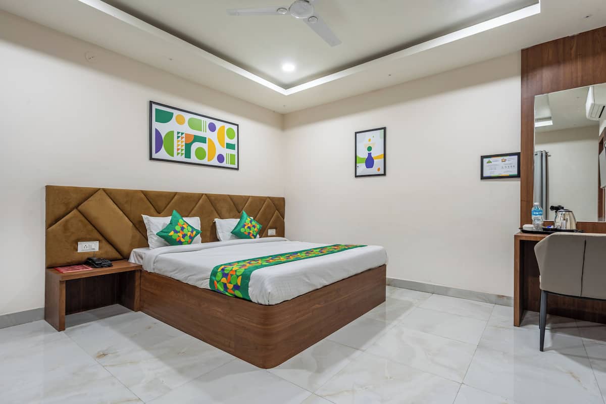 Una habitación de hotel moderna con una cama grande, un escritorio y una silla.