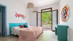 Un dormitorio con cama, escritorio, ventana y puerta.