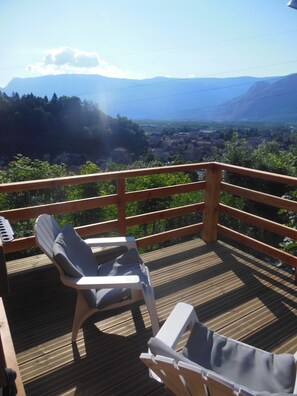 A wooden deck with two lounge chairs, a railing, and a scenic view of a valley and mountains. - Holiday Home 'Gite 33m2, Vue Sur Le Vercors' with Mountain View, Private Terrace and Wi-Fi (Vinay)