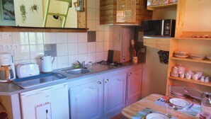 Pieni, käytännöllinen keittiö, jossa on pesuallas, leivänpaahdin, kahvinkeitin ja mikroaaltouuni.