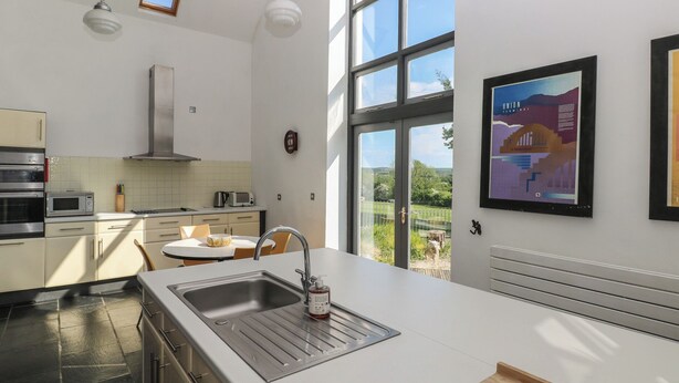 Una cocina moderna con un ventanal grande, electrodomésticos de acero inoxidable y vistas al exterior.
