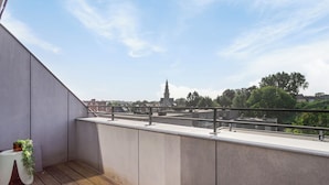 A balcony with a view of a cityscape, including a prominent tower. - Spacious 3 bedroom apartment with parking (Machelen)