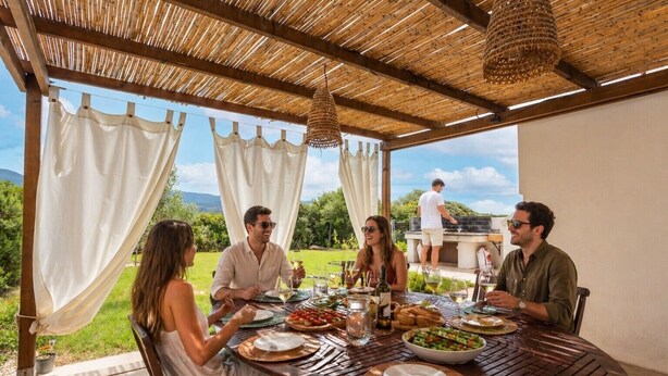 A covered outdoor dining area with a table set for four people, surrounded by greenery and a view of the landscape. - Holiday Home 'Santa Caterina' with Mountain View, Wi-Fi and Air Conditioning (Santa Caterina di Pittinuri)