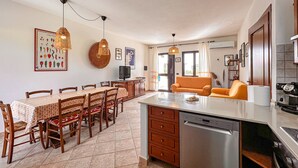 A kitchen with a dining area, a sofa, and a dishwasher. - Holiday Home 'Santa Caterina' with Mountain View, Wi-Fi and Air Conditioning (Santa Caterina di Pittinuri)