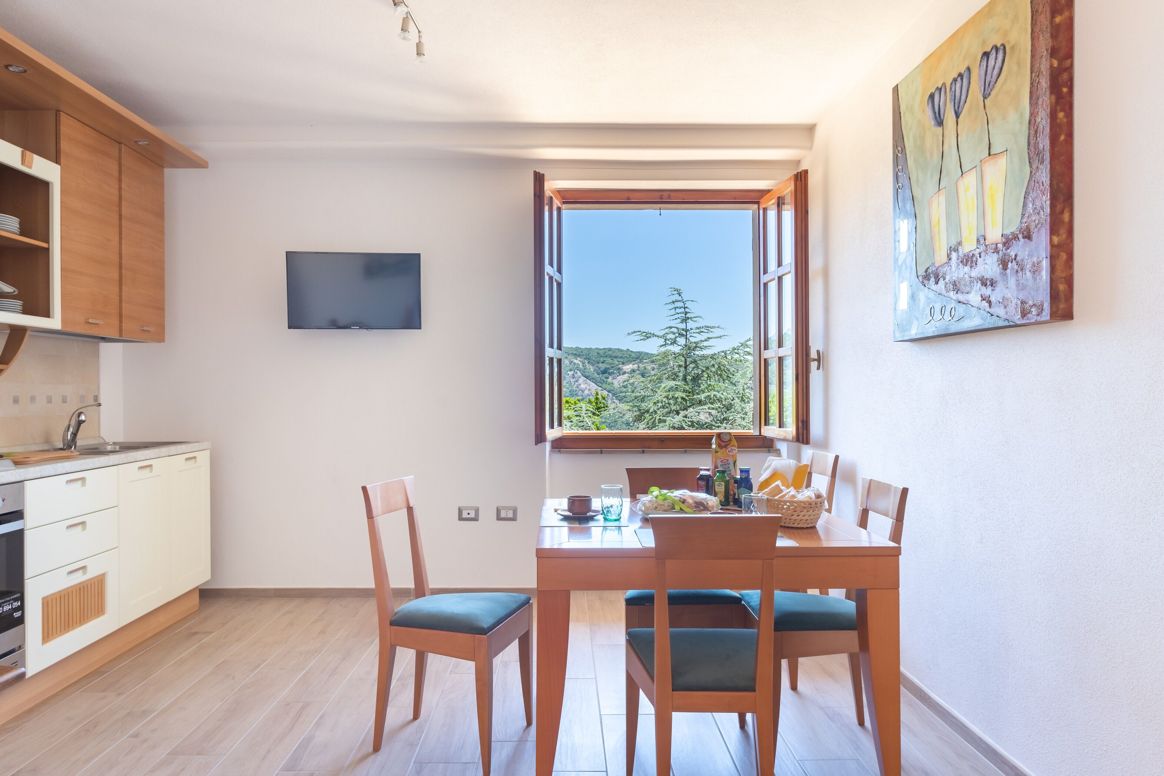 A modern kitchen with wooden cabinets, a built-in oven, and a dining area with a table and chairs.