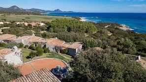 A coastal village with stone buildings, a beach, and a view of the sea.
