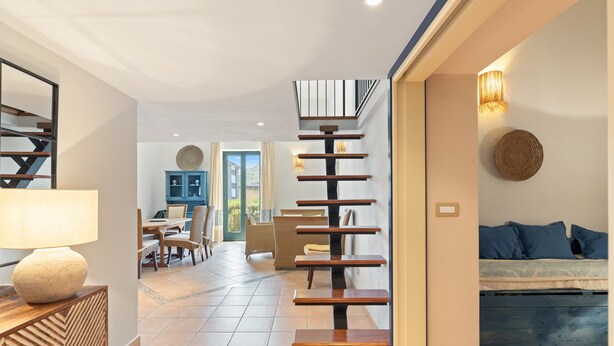 A modern interior with a staircase, a dining area, and a sofa. - Apartment 'La Residenza Color Del Mare' with Balcony, Wi-Fi and Air Conditioning (Bosa)